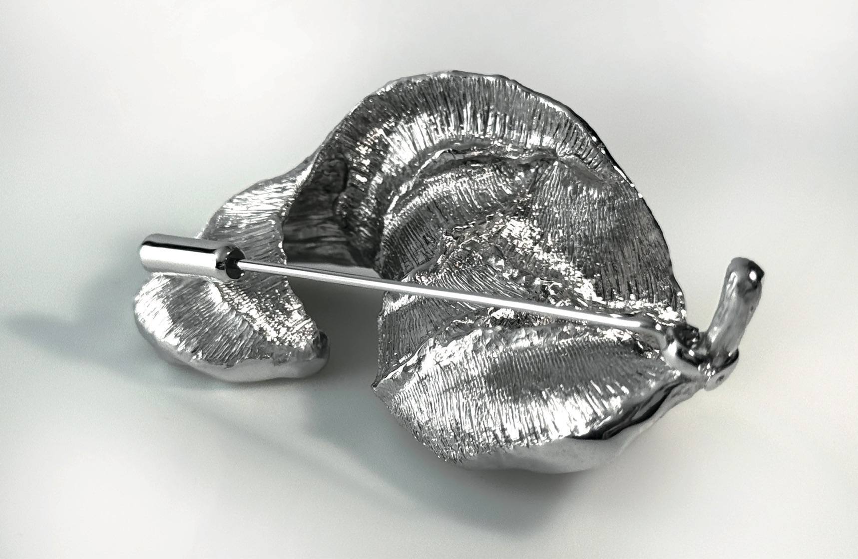 The reverse of the brooch, showing the silver pin mechanism.